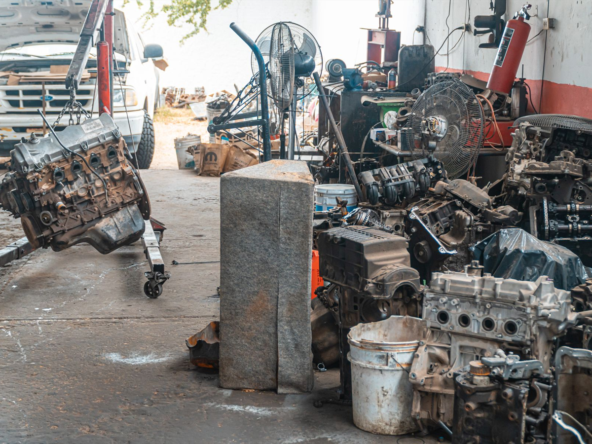 Söküm sonrası ayrılmış motor blokları ve kaldırıcıda bekleyen bir motor